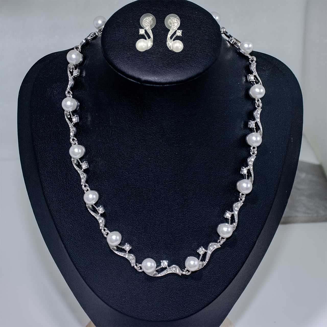 This elegant two-piece set includes a water-drilled imitation pearl necklace and matching earrings, perfect for women who love light luxury and versatility. The necklace can be worn as a sweater chain or a clavicle chain, and is adorned with golden