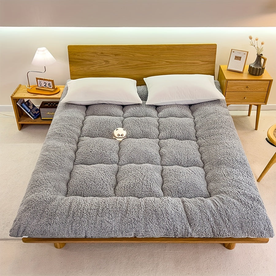 Soft, reversible gray mattress protector with corner straps for easy storage and transport. Ideal for cozy bedrooms.