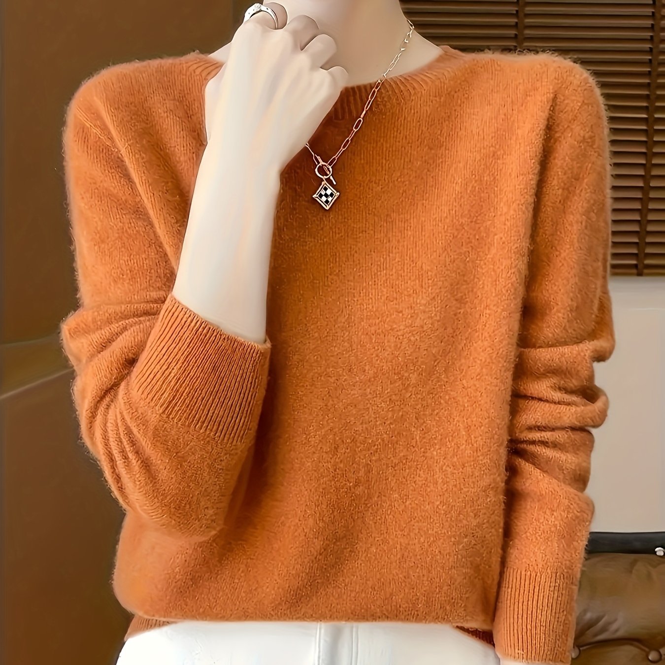 Stylish women's merino wool sweater with cozy crew neck, long sleeves, and solid color knit design for fall/winter.