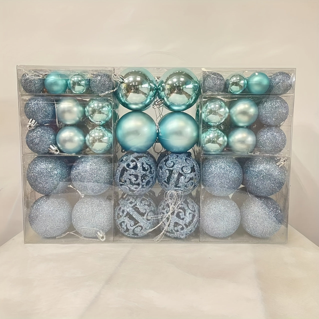 100-piece set of shatterproof plastic Christmas ball ornaments in a hand-held gift box, suitable for holiday decoration. No feathers included.