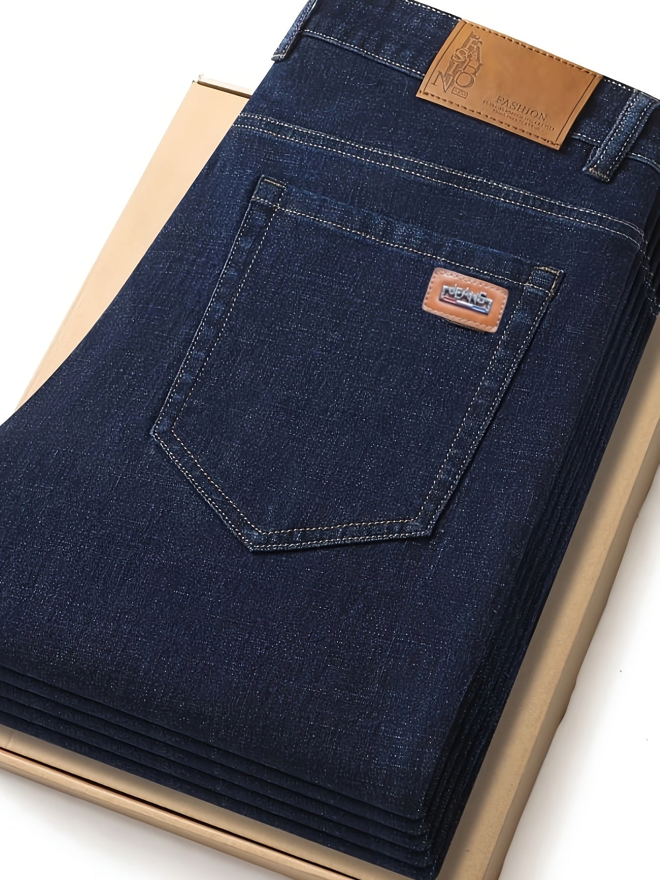 Men's dark blue jeans with patch, straight leg fit, ribbed cuffs, and durable cotton blend denim. Machine washable, comfortable, and smooth fabric.