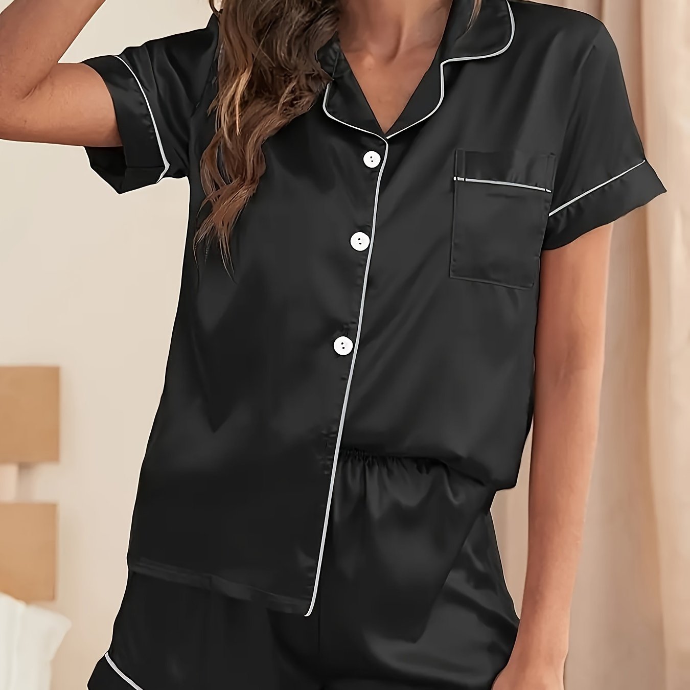 Women's satin pajama set in solid color with short-sleeved lapel top and elastic waistband shorts.