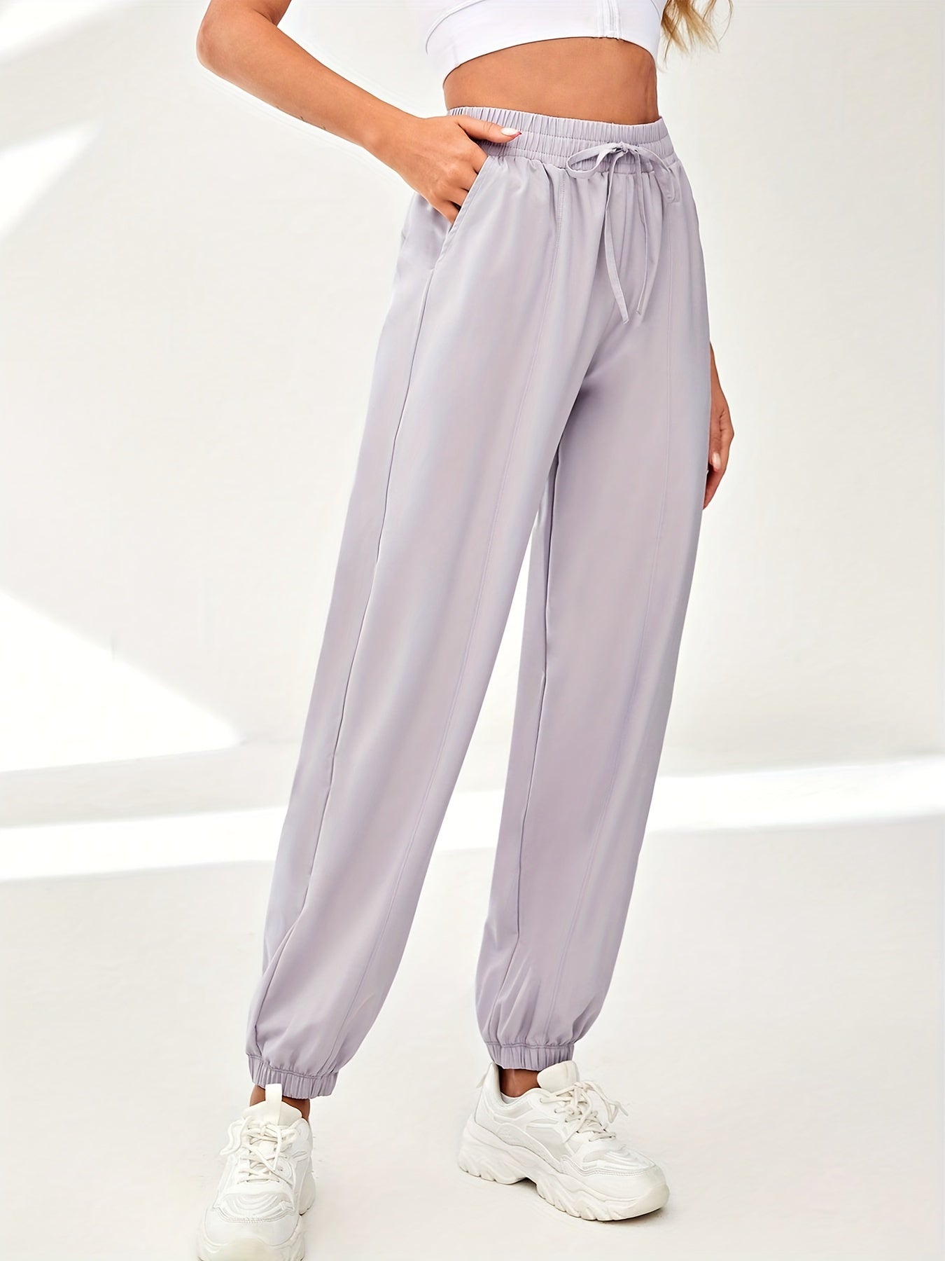 Solid color quick-drying sweatpants with drawstring elastic waist for women's athleisure.