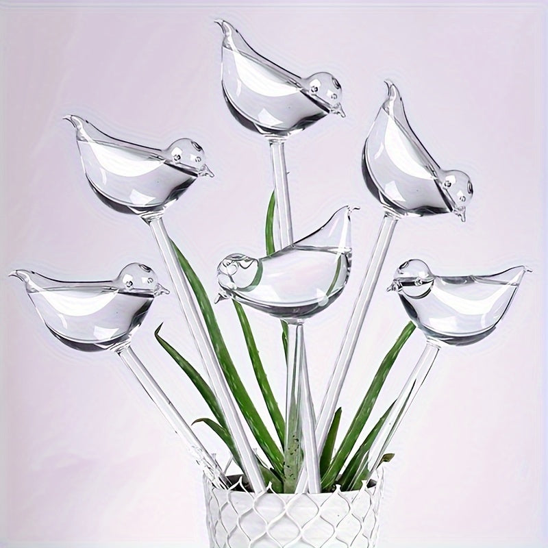 Set of 5 self-watering bird-shaped globes for automatic watering of flowers and gardening tools at home.