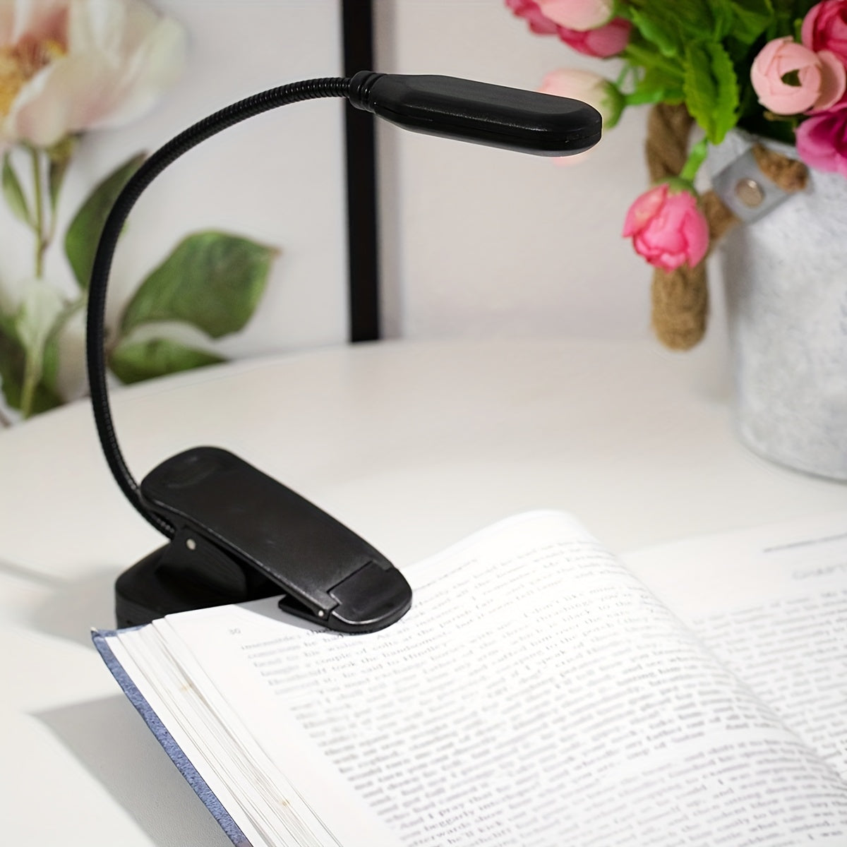 Portable battery-powered clip-on book light with a flexible hose, ideal for reading in small spaces or as a bedside night light.