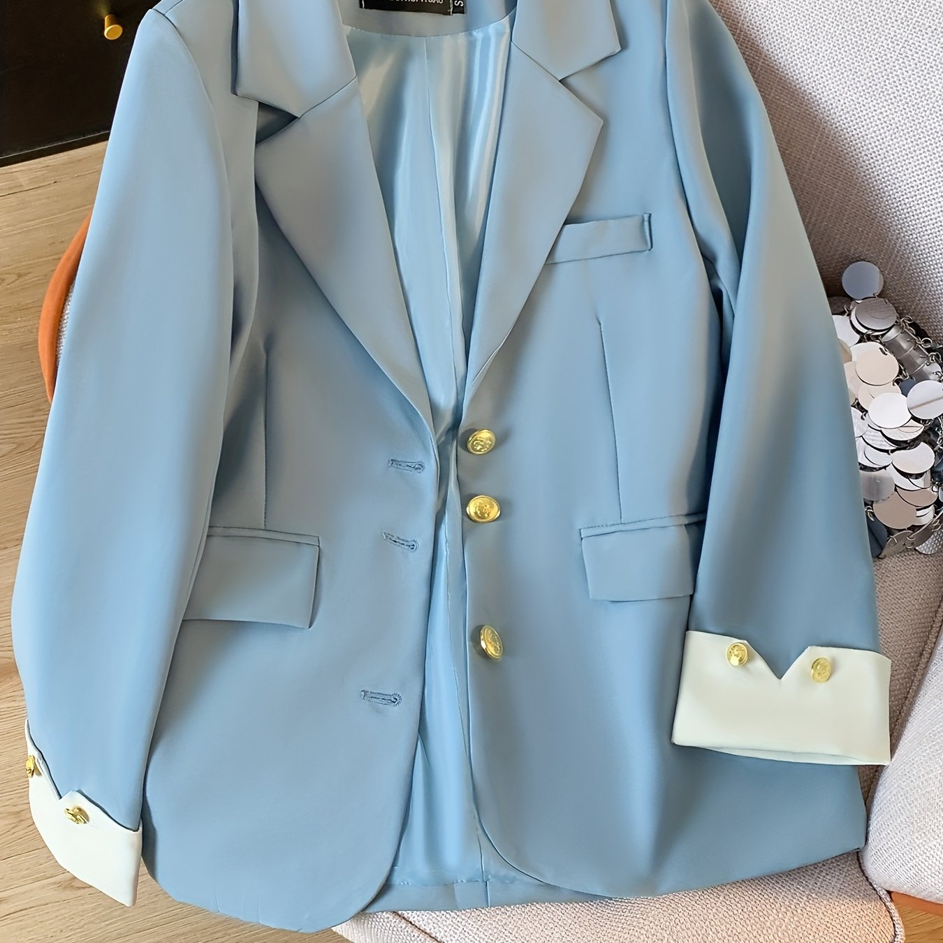 Stylish light blue blazer with golden button details for women, ideal for work in spring and fall.