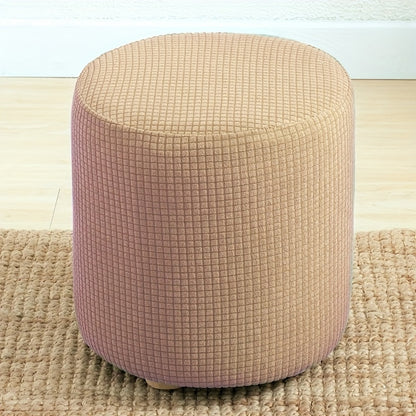 Stretchable round footstool cover made from soft polyester blend with elastic fit. Available in multiple colors, machine washable, modern design for living room ottomans.