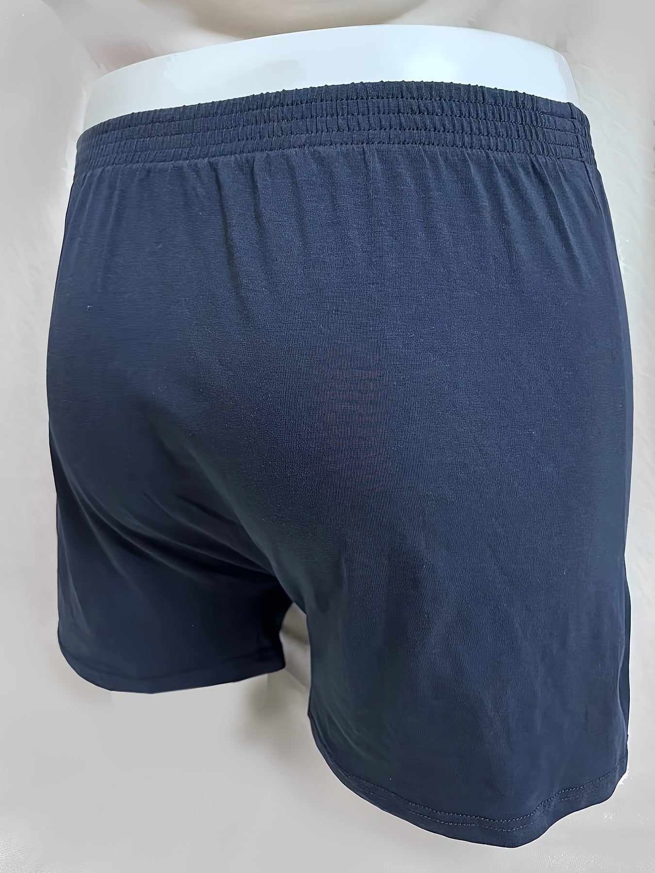 Three men's cotton boxer briefs in black, navy, and light blue with elastic waistband and no-ride design.