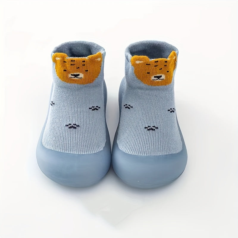 Cute lion cartoon slip-on sock shoes for baby boys in light blue with yellow accents. Soft, breathable, and non-slip rubber sole, perfect for first walkers in spring and fall.