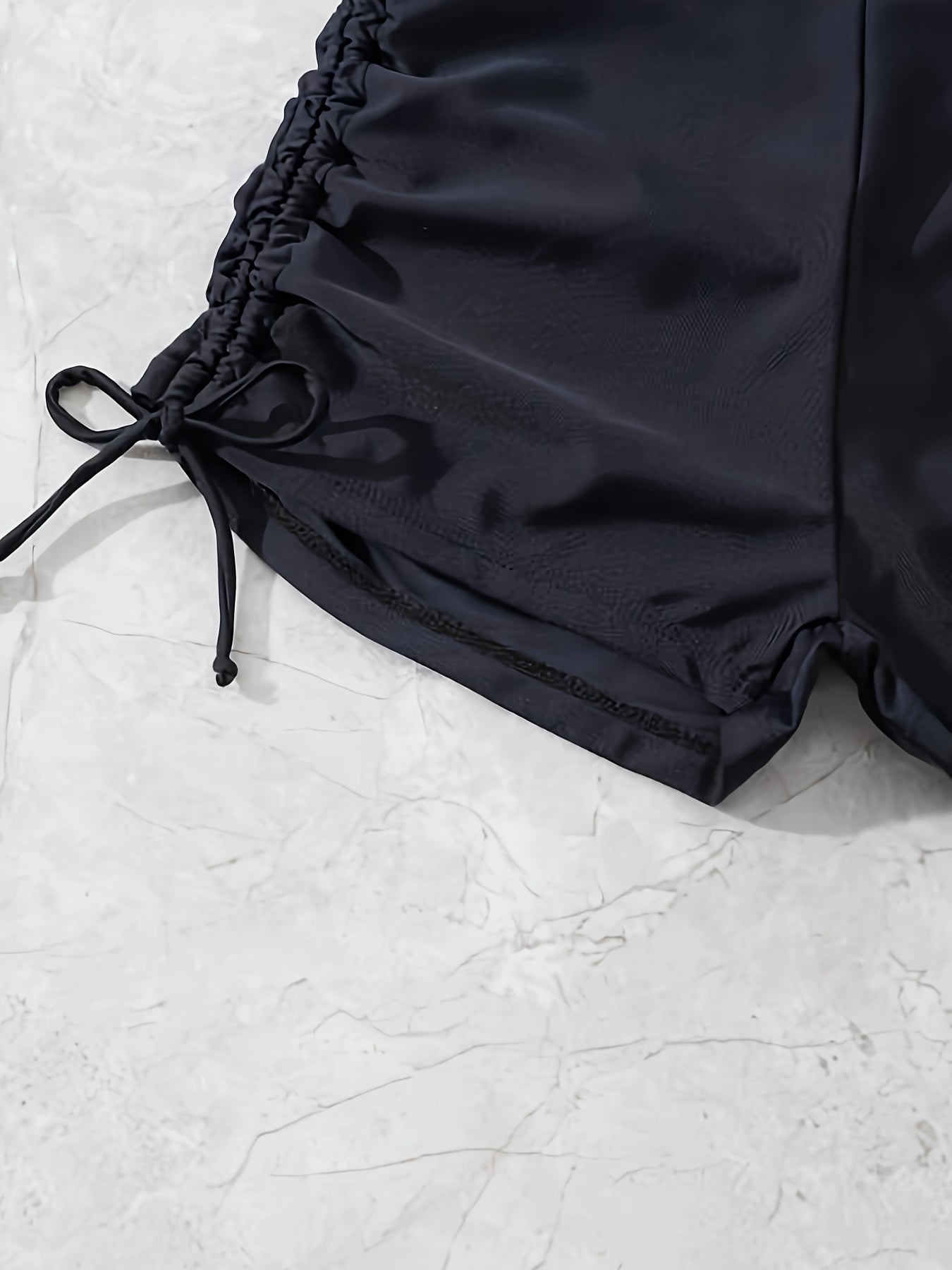 Black drawstring swim shorts for women.