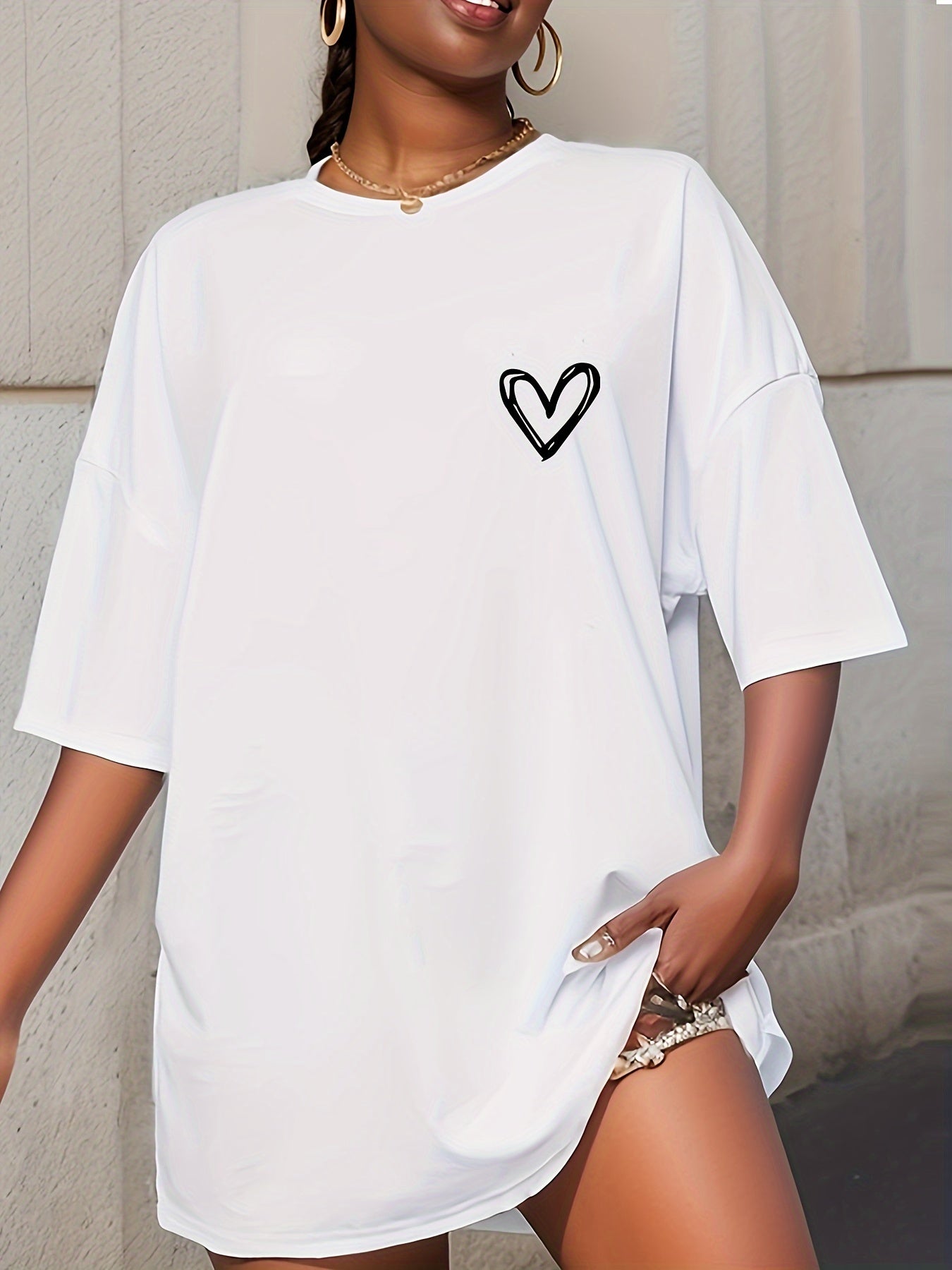 Casual loose-fit drop shoulder t-shirt for women with chic heart print. Made of soft polyester, short sleeve, and round neck. Machine washable and perfect for everyday style.