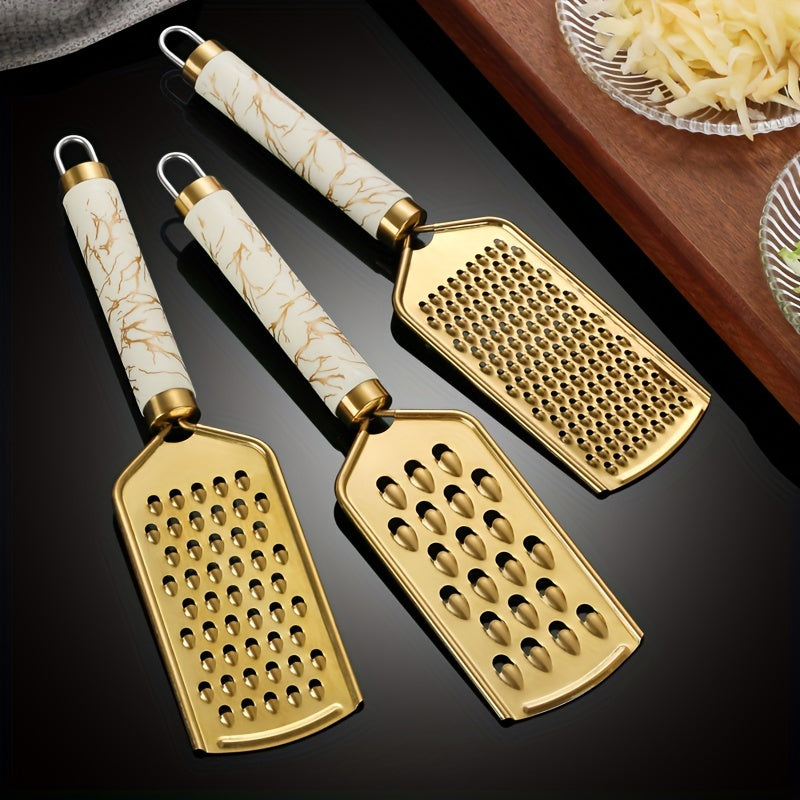 Stainless steel kitchen grater for shredding various foods, with a safe handle and luxurious golden appearance.