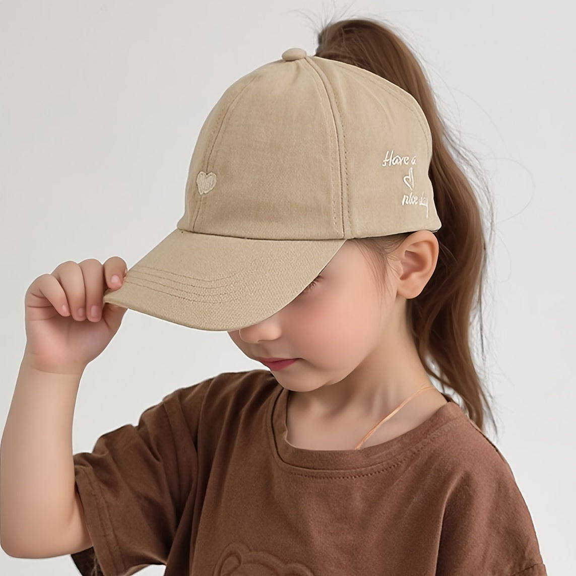 Youngsters' sun protection baseball cap made of 100% polyester with heart pattern, snap closure, and ponytail opening. Suitable for ages 5-10 for daily and casual wear in spring/summer