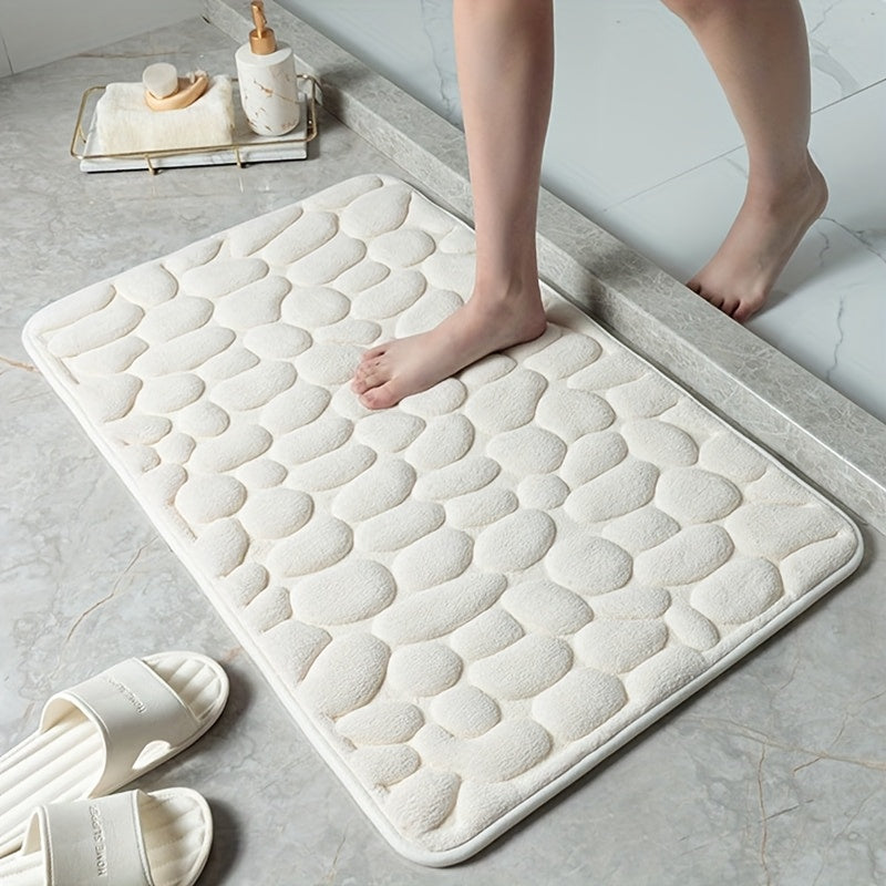 The Coral Fleece Non-Slip Bath Mat features a pebble design and is made of memory foam for ultimate comfort. This machine-washable bathroom rug has a solid pattern, flat woven construction, and low pile for easy care. It has a weight of 400gsm and comes