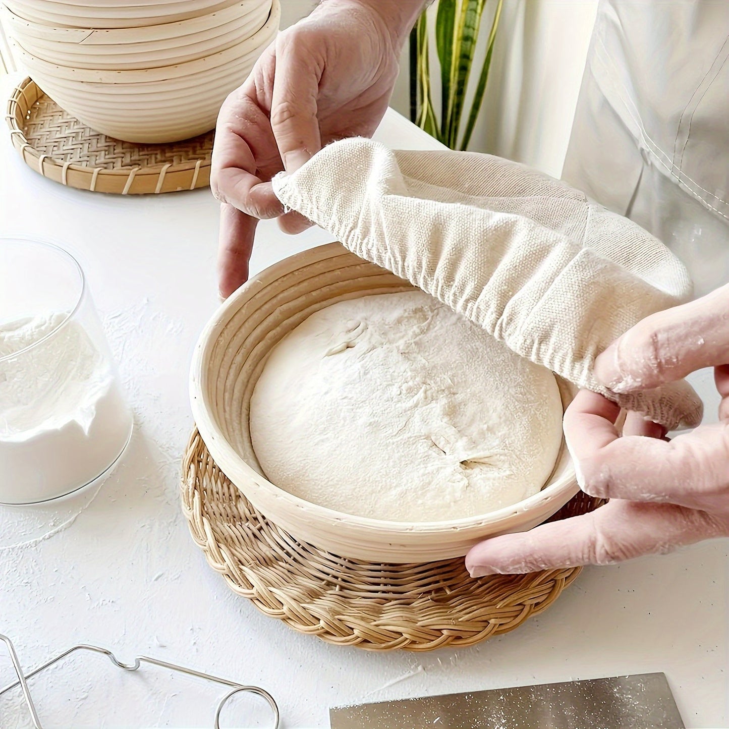 Set of two modern round bread proofing baskets with liners made from rattan. This banneton basket kit is ideal for baking artisan sourdough bread, providing a non-stick fermentation basket for home bakers and bread making.