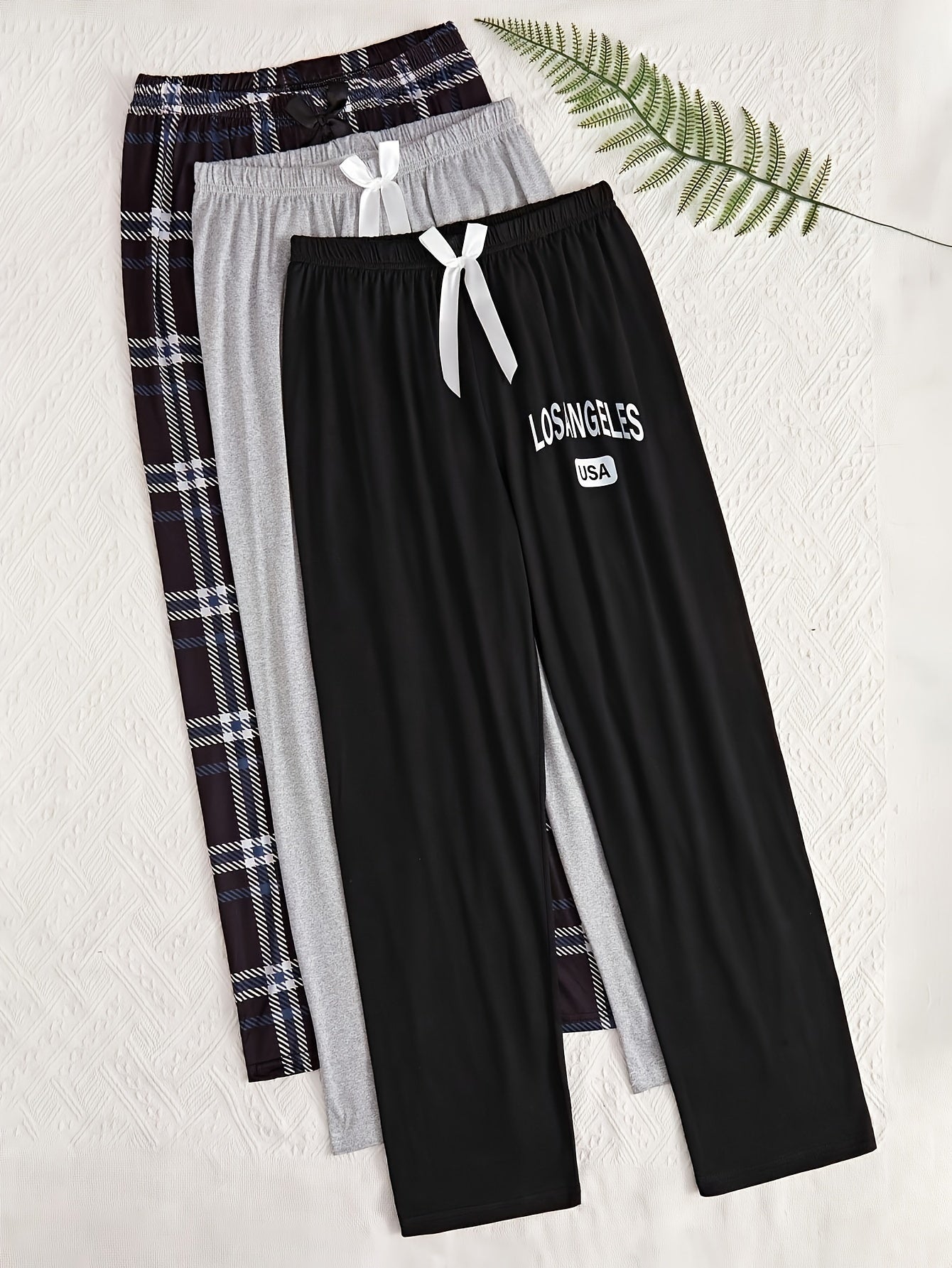 3 Women's lounge pants with plaid and "LOS ANGELES" print. Made of comfy polyester blend with elastic waist and bow detail. Suitable for all-season sleepwear and casual wear.