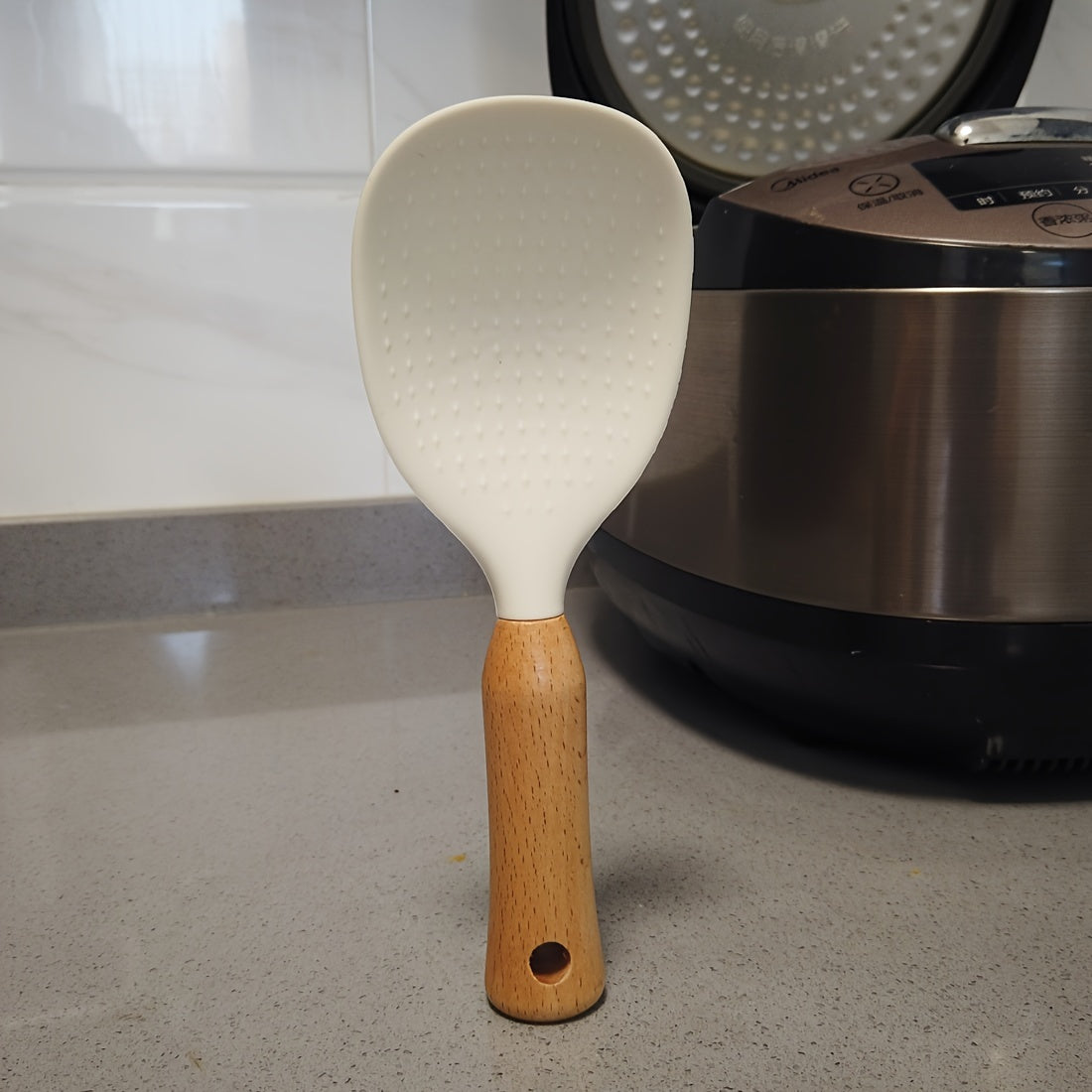 Silicone rice spoon with wooden handle, ideal for non-stick cookware, durable and convenient serving utensil.