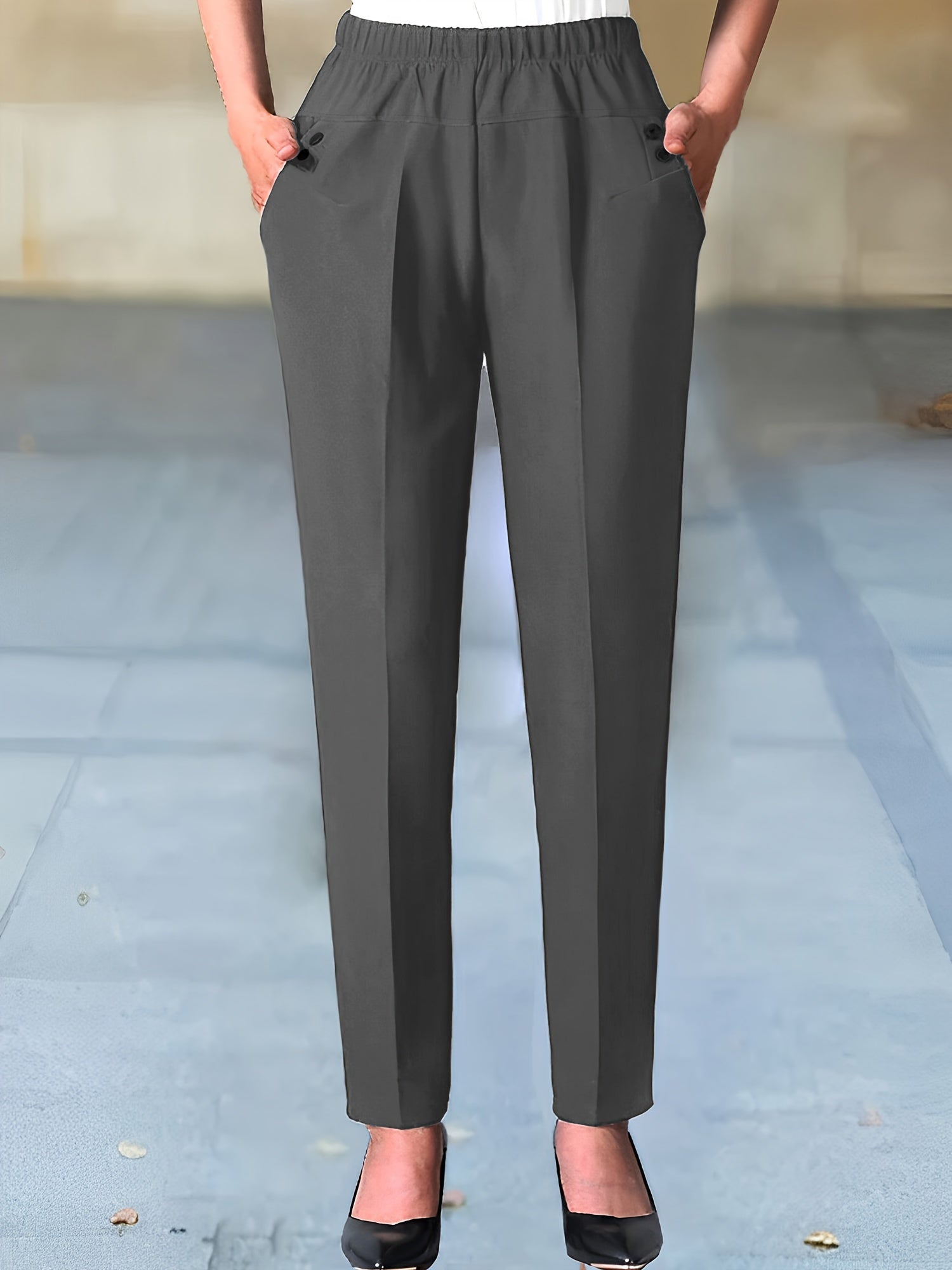 Women's solid color tapered pants with dual pockets and an elastic waist, suitable for work and office wear.