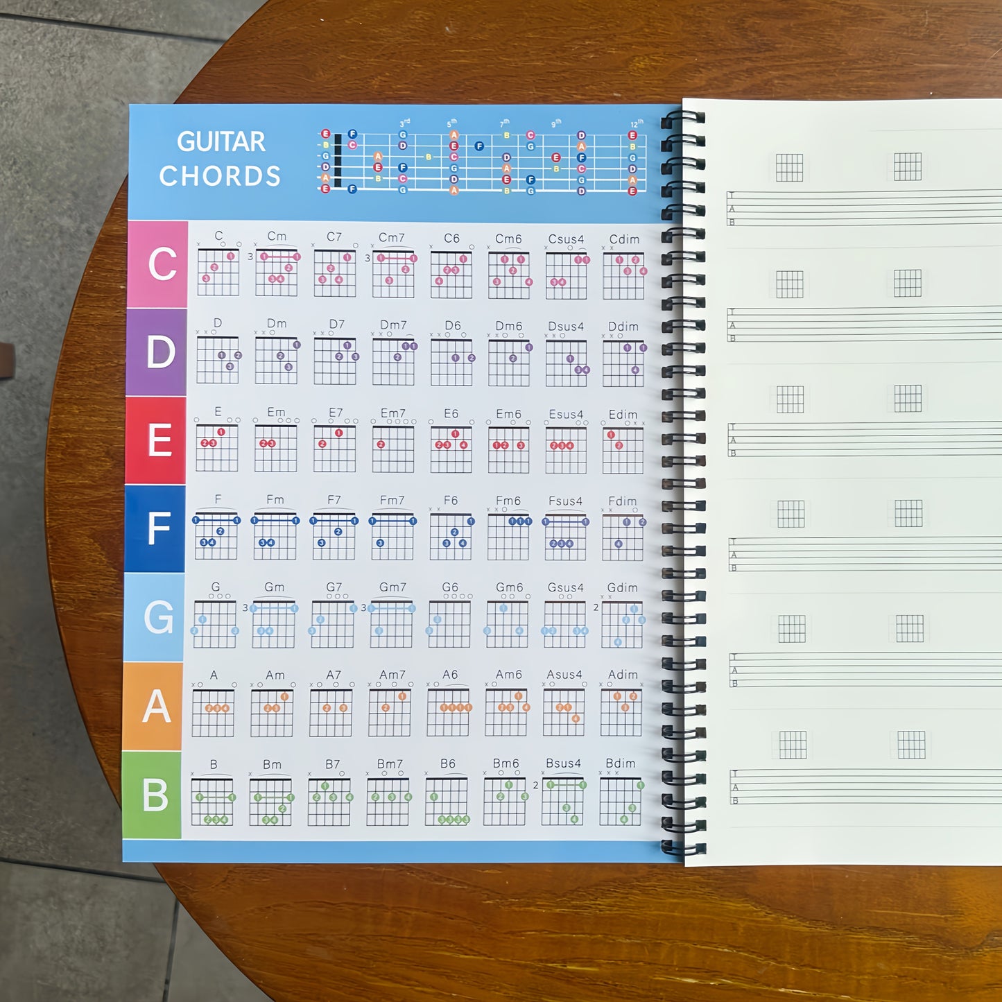 50-sheet guitar music creation and practice staff notebook with blank chord diagrams and 56 commonly used guitar chord diagrams on inside cover.