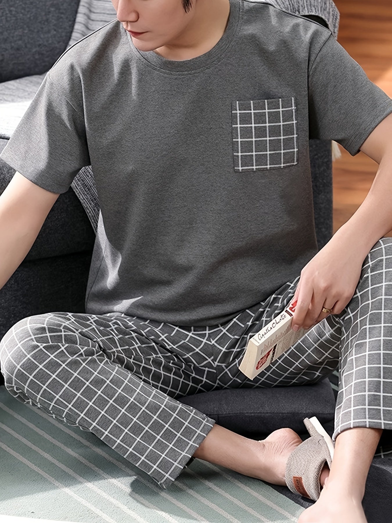 Men's 2-piece plaid pajama set includes round neck top and matching trousers for cozy loungewear comfort.