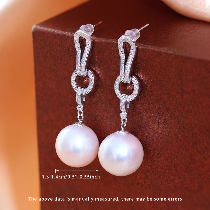 Add a touch of elegance to your collection with these must-have Pearl Dangling Earrings. Crafted with 13-14mm round natural freshwater pearls, these fashionable long earrings are made of S925 silver. Each pair is unique and features varying shapes and