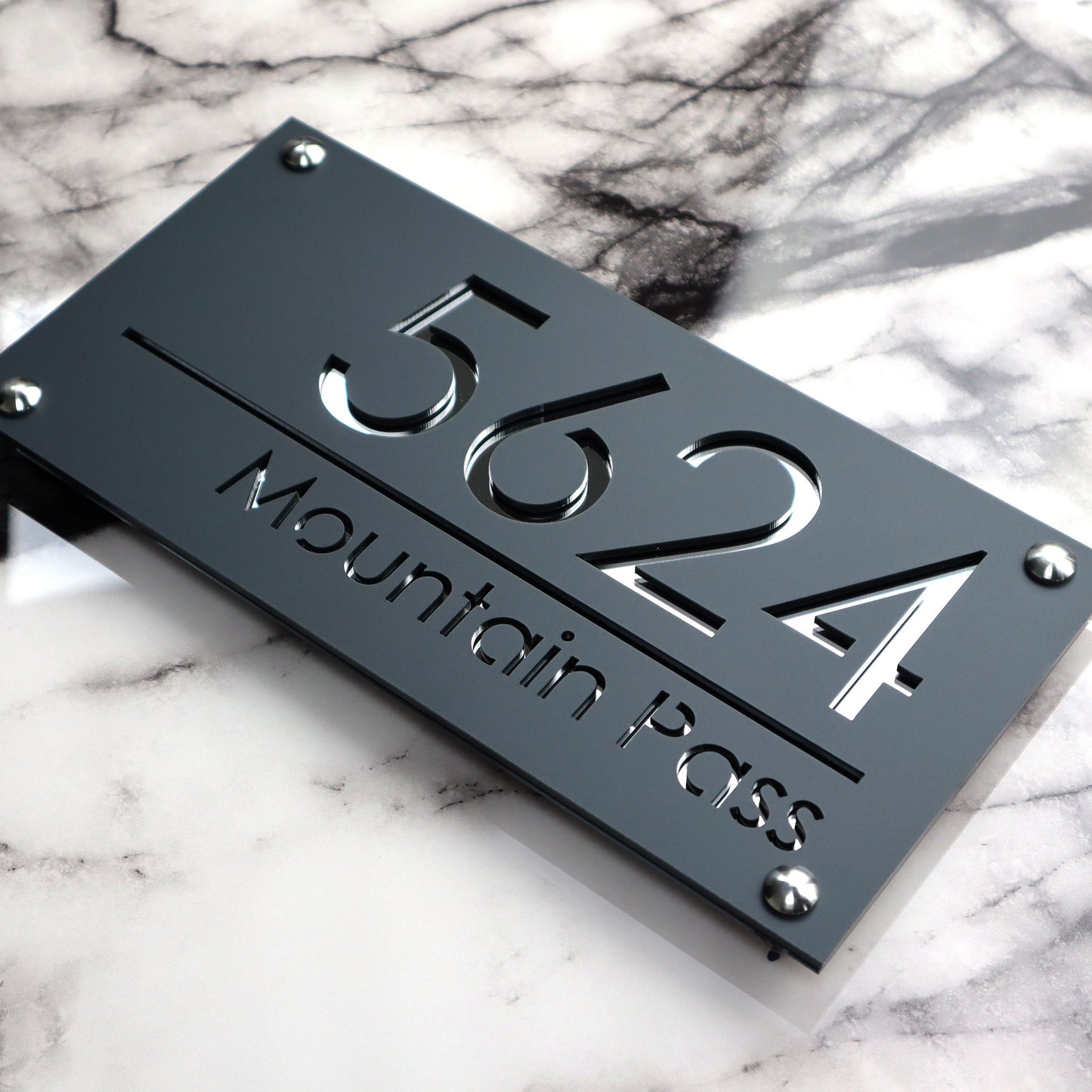 Custom British house number sign made from laser-cut acrylic with a matte gray and silvery mirror finish.