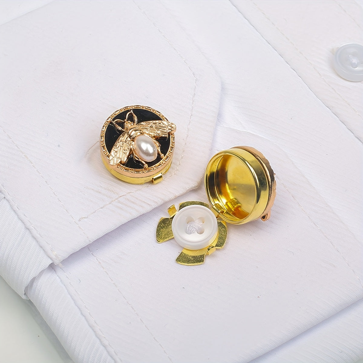 Get a pair of elegant Golden Bee cufflinks and shirt buttons set for a fashionable and seamless look. Made of shiny copper, these clip-on buttons are perfect for formal tailcoat attire and add a touch of luxurious decoration to your clothing. This fancy