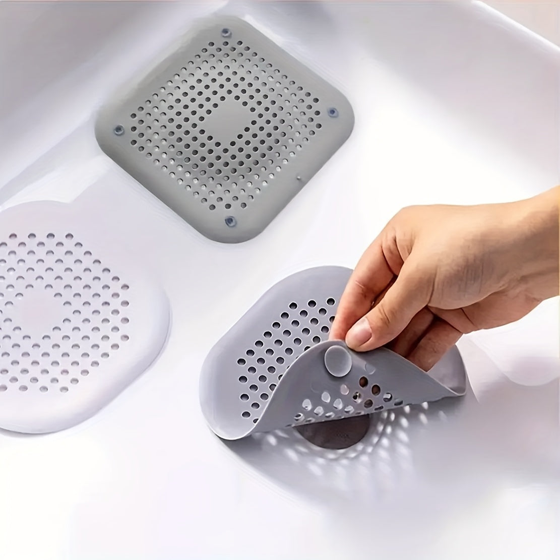 Durable white hair catcher for kitchen and bathroom drains, odorless and anti-clog design, made of thermoplastic rubber material.