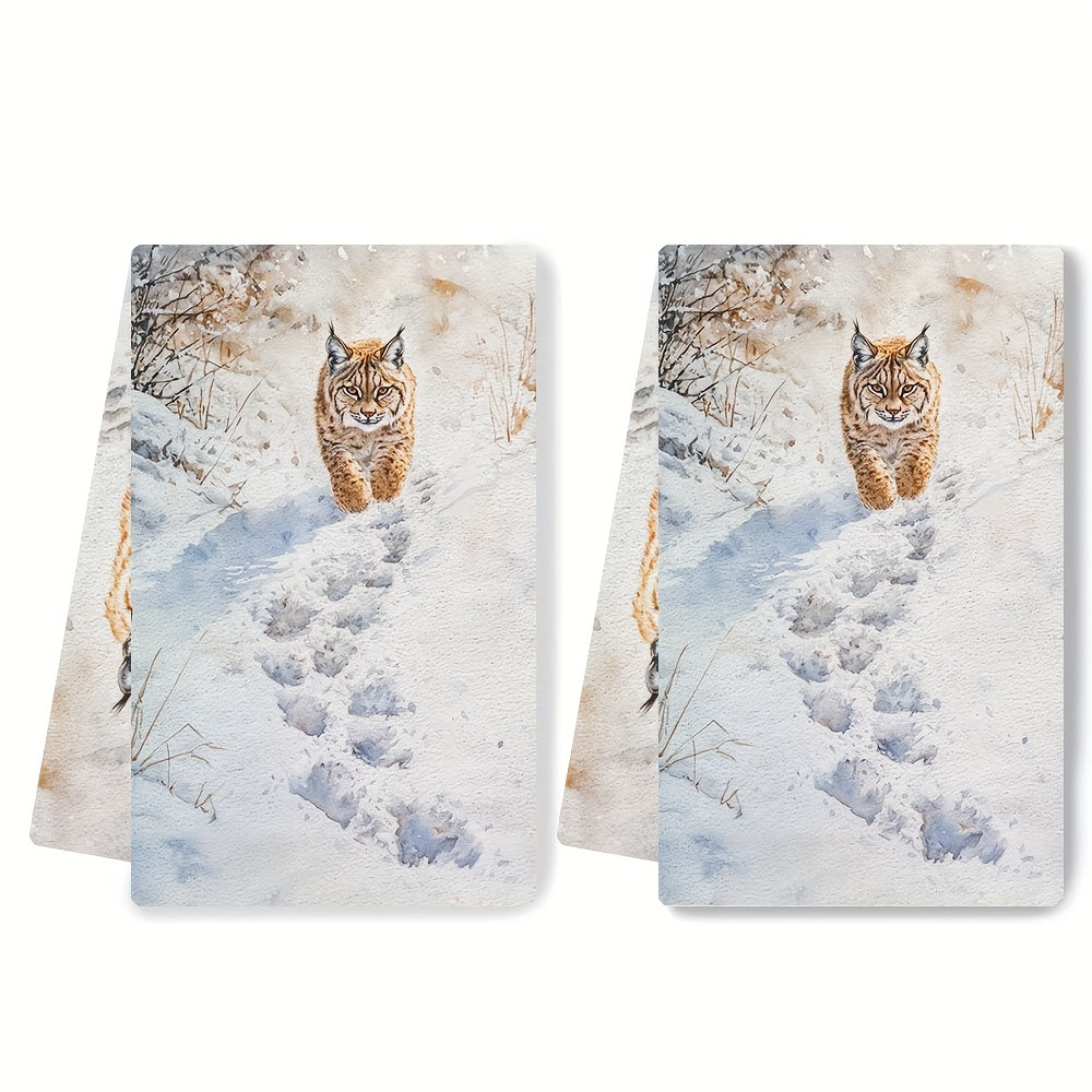 Two pieces of Lynx Snow Footprints kitchen towels, made of super absorbent polyester knit fabric. These towels are machine washable and feature a contemporary coastal style, measuring 40.64x60.96 cm. They are perfect as dish hand towels for holiday decor.