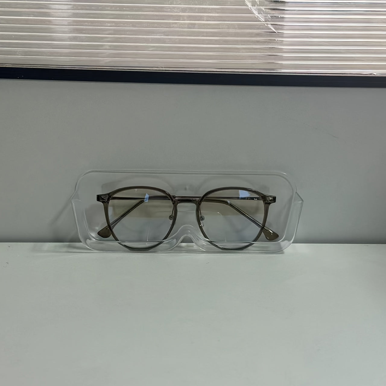 Wall-mounted sunglasses display rack for organizing and storing glasses.