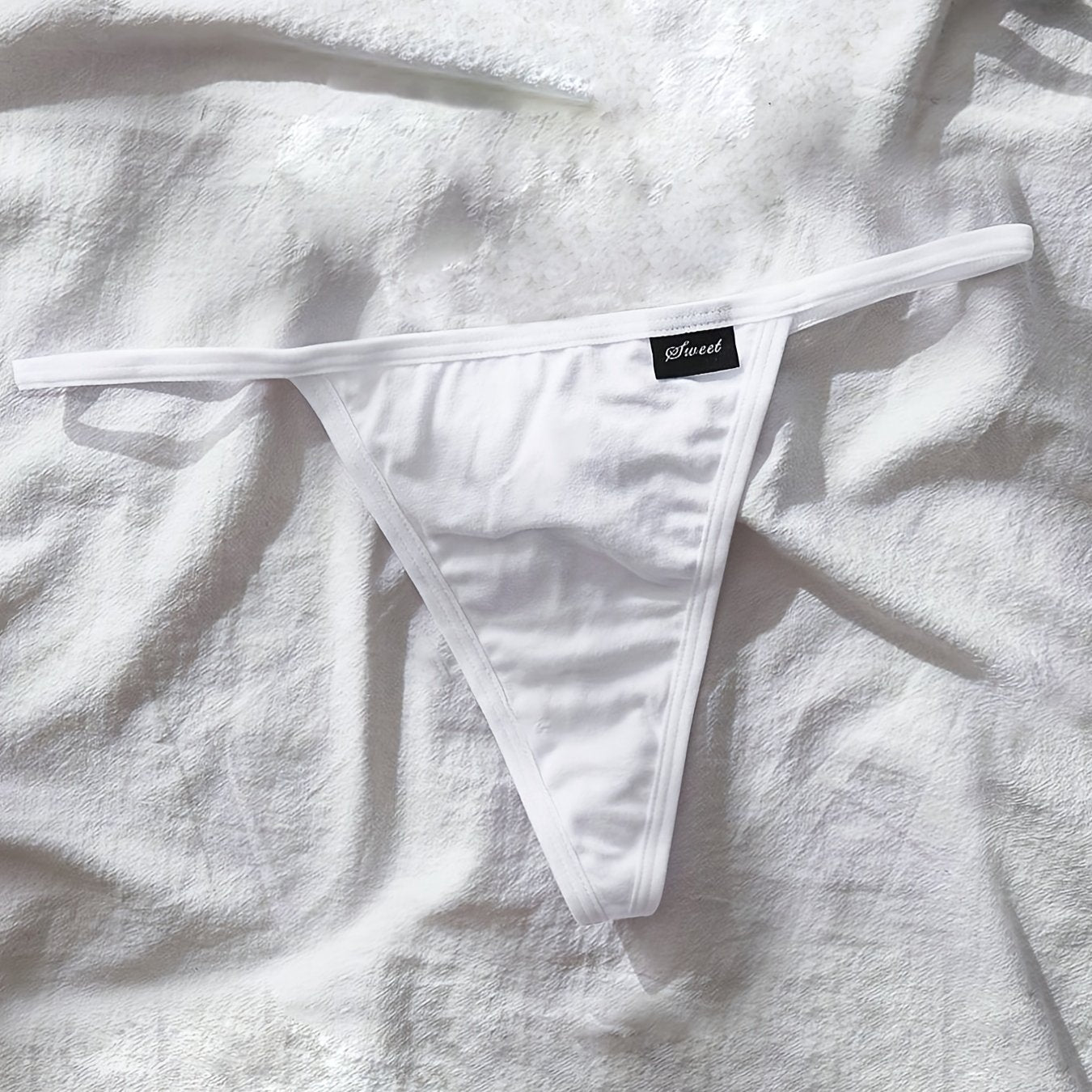 Plus size women's white thong panties with soft stretch fabric and "SANQIU" waistband.