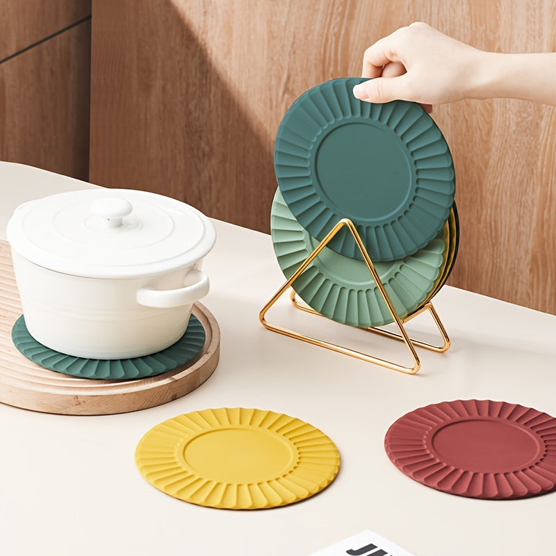 Set of 6 silicone cup coasters with a round sunflower design and metal holder, perfect for protecting your kitchen table from heat. These heat-resistant mats can also be used as dining placemats or pot pads. Includes 1 holder and 5 coasters.