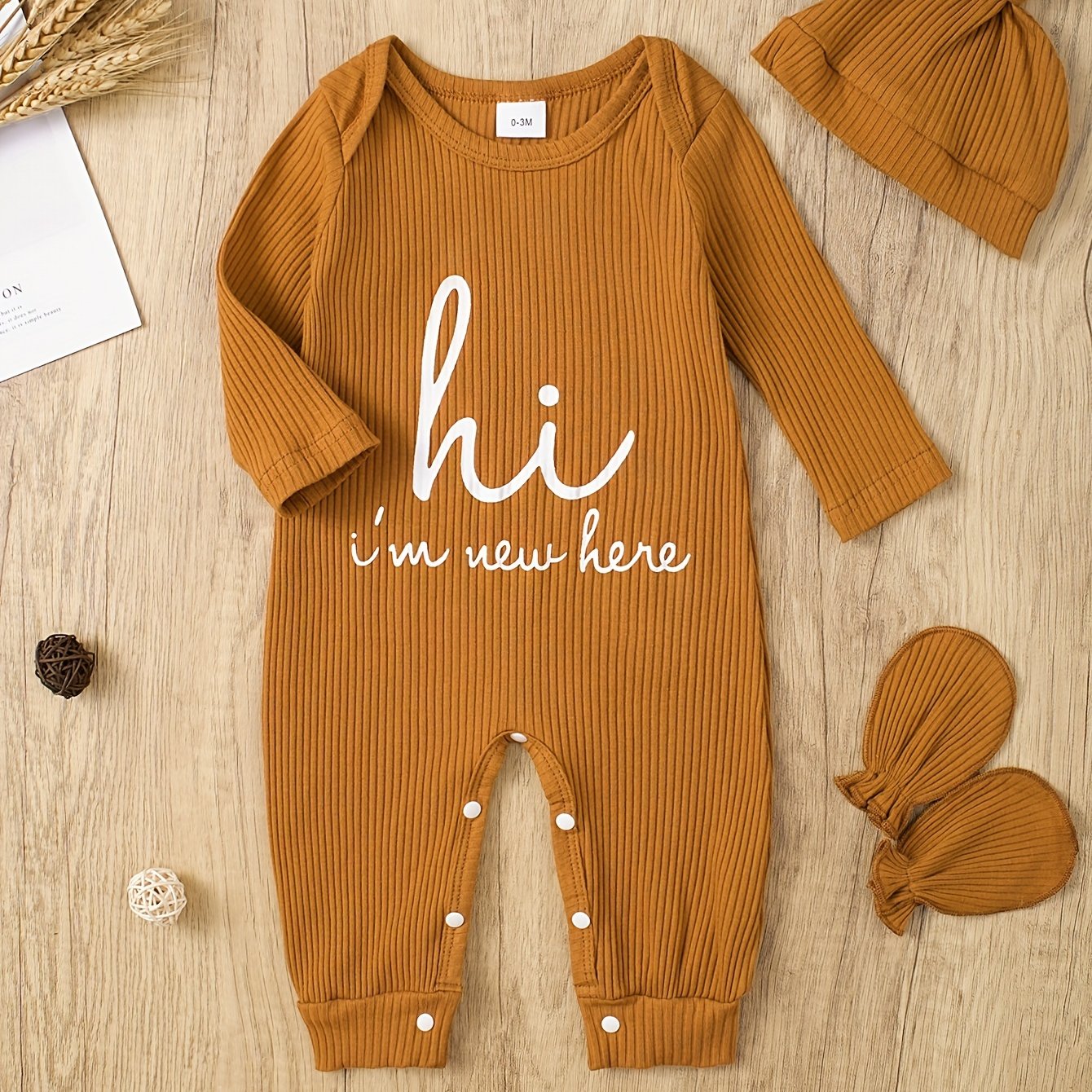 Newborns' "Hi I'm New Here" outfit: long-sleeve romper, hat, and gloves for boys and girls for outdoor wear.