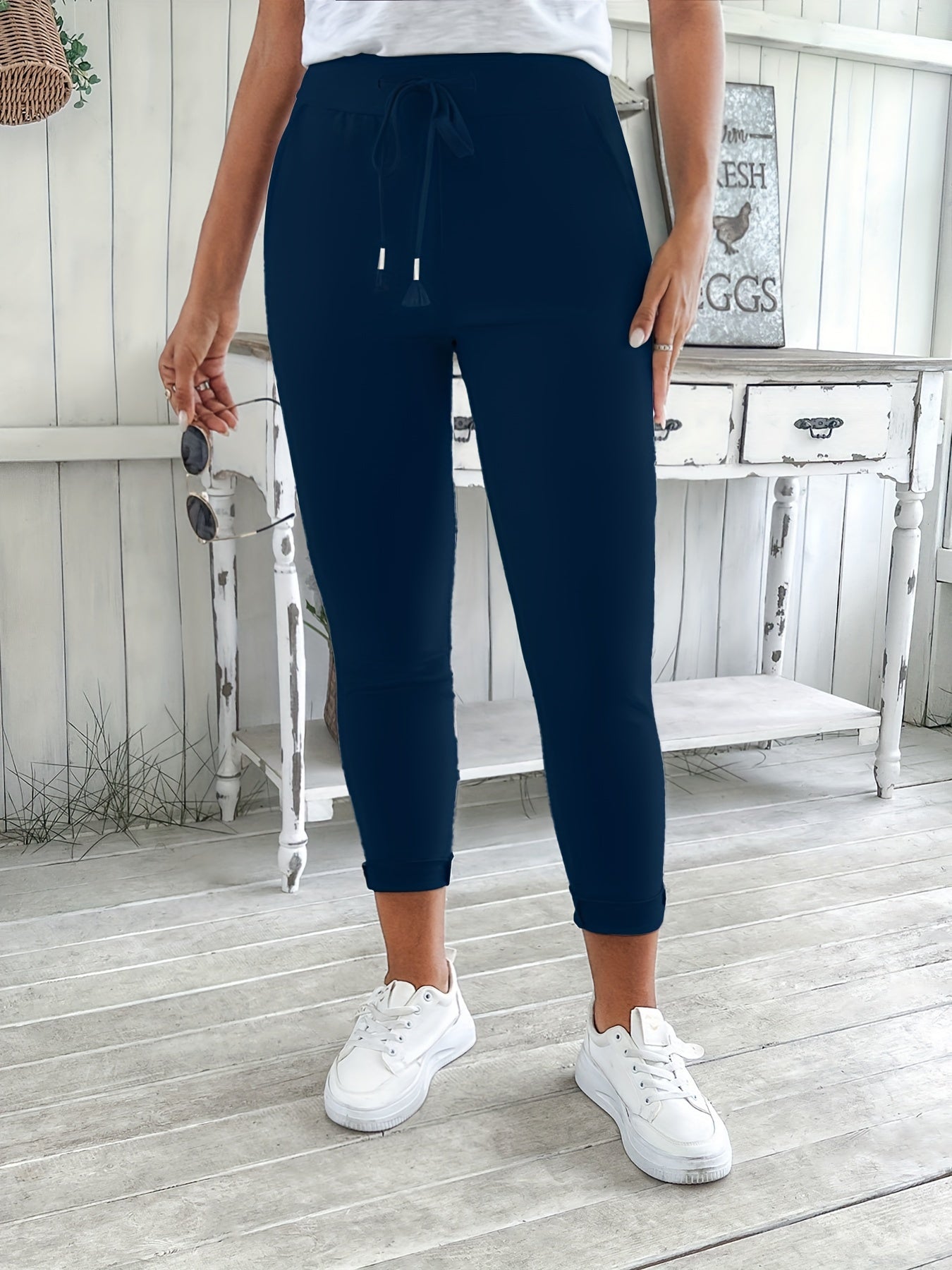 Navy blue drawstring jogger pants for women. Made of stretchy polyester with pockets. Machine washable. Comfortable and adjustable, perfect for all seasons.