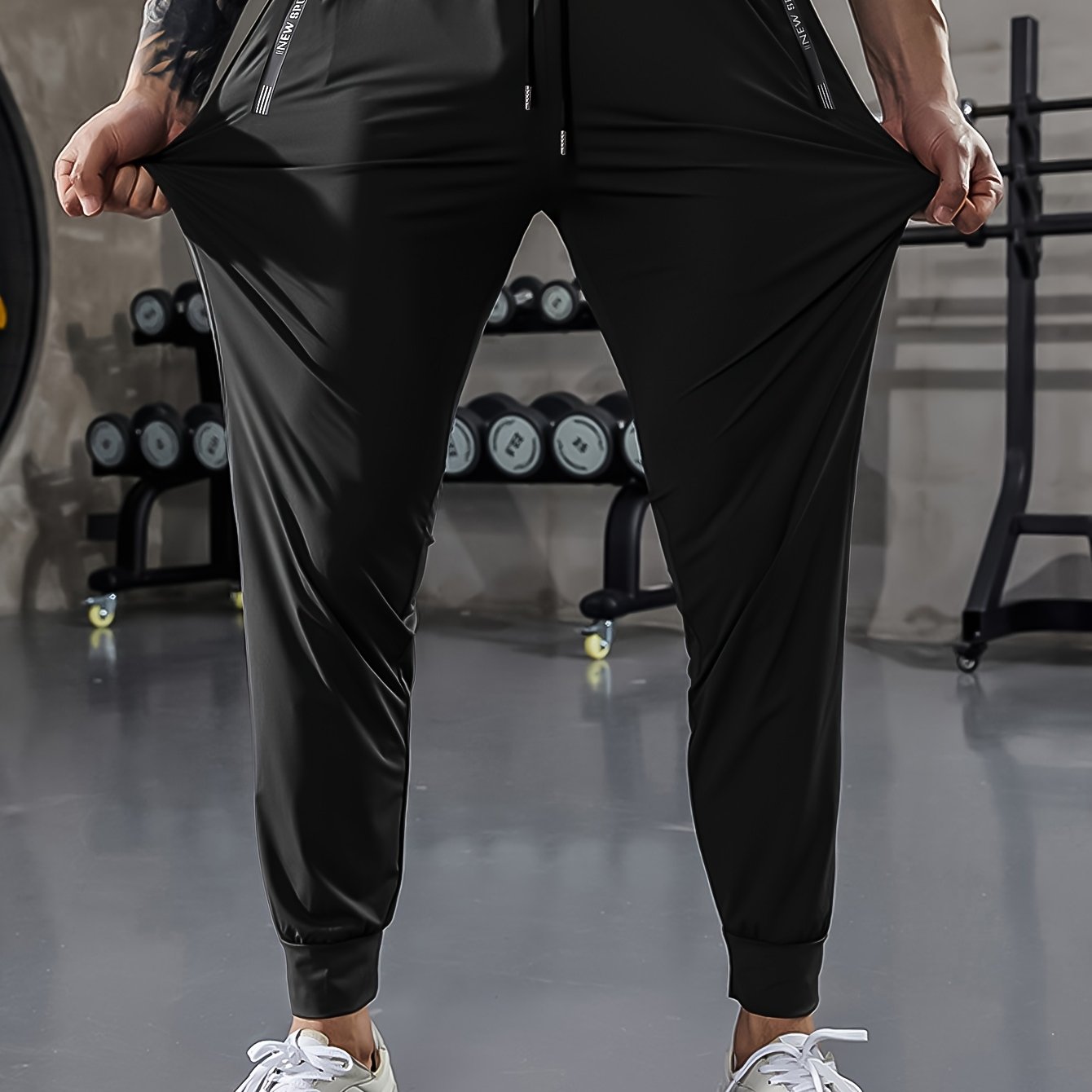 Men's athletic stretch pants with adjustable drawstring waist, zippered pockets, solid color, quick-dry material, ideal for fitness and running.