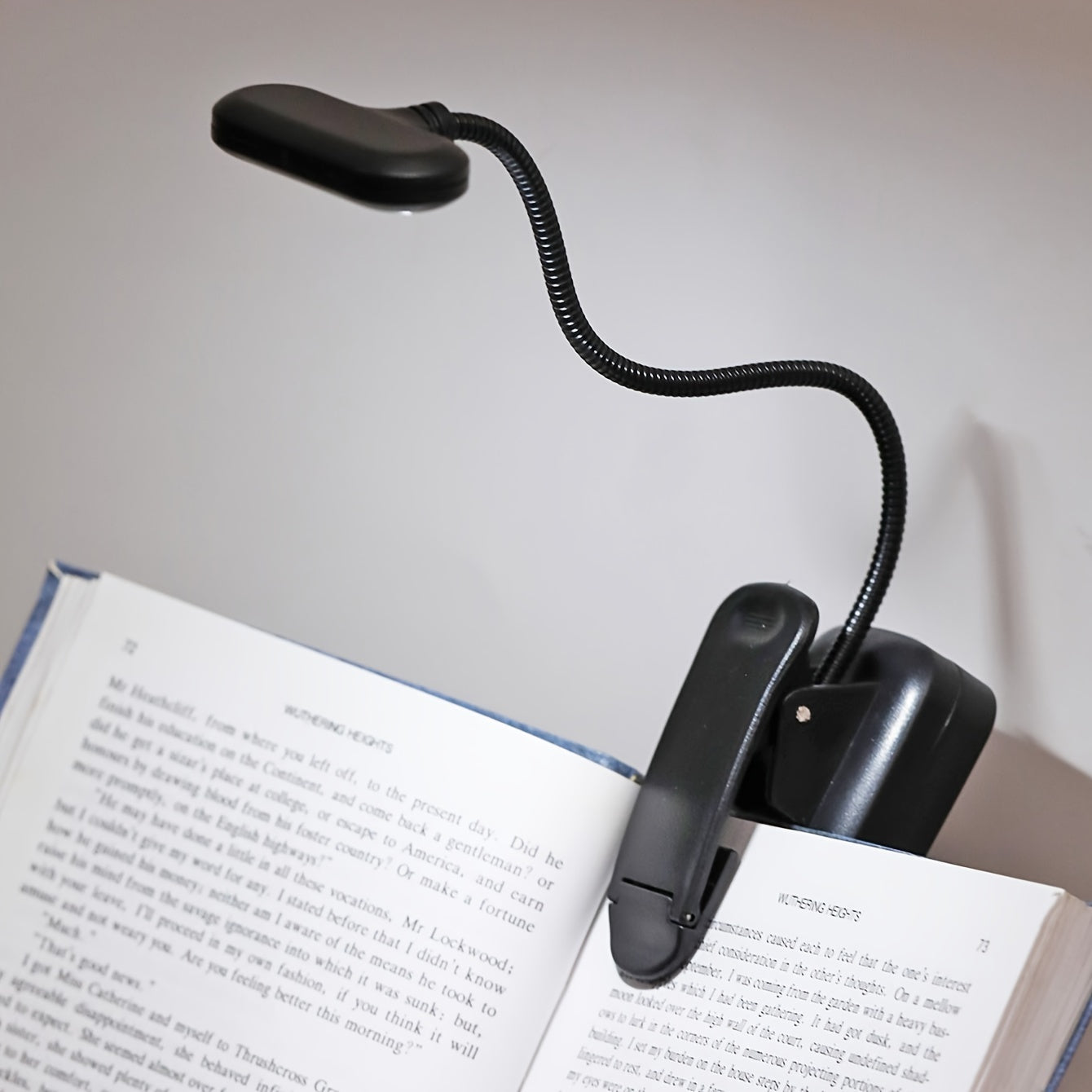 Portable battery-powered clip-on book light with a flexible hose, ideal for reading in small spaces or as a bedside night light.