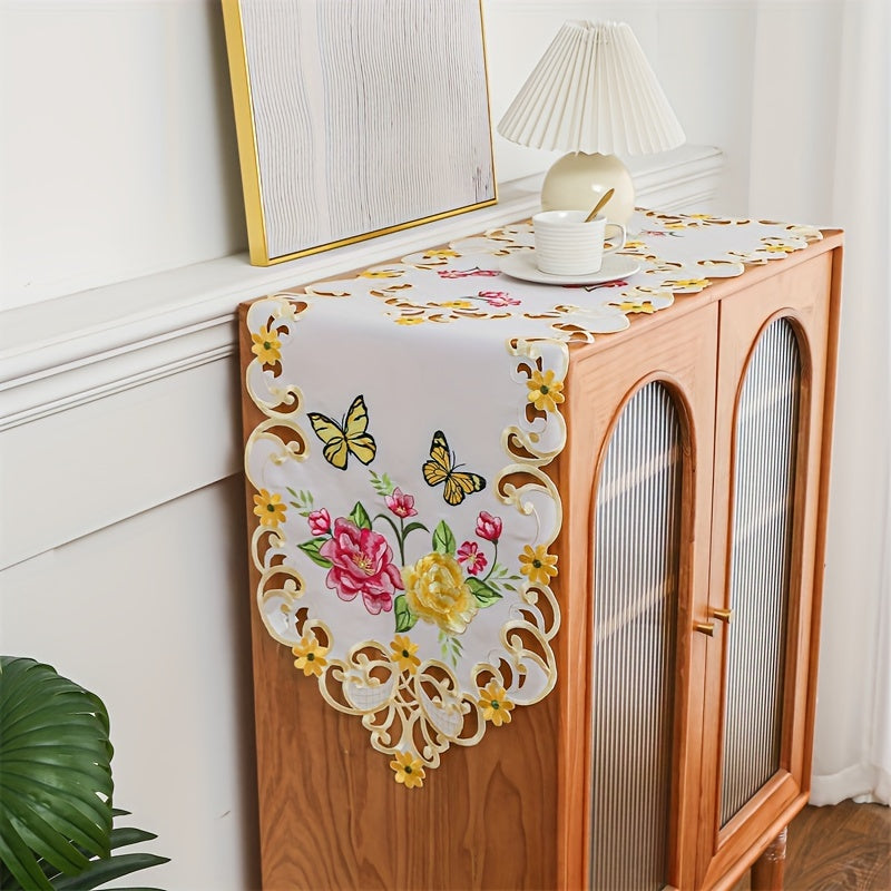 Elegant polyester table runner with hand-cut embroidered flowers and butterflies, perfect for home decor, restaurants, picnics, and parties. White base with vibrant floral patterns.