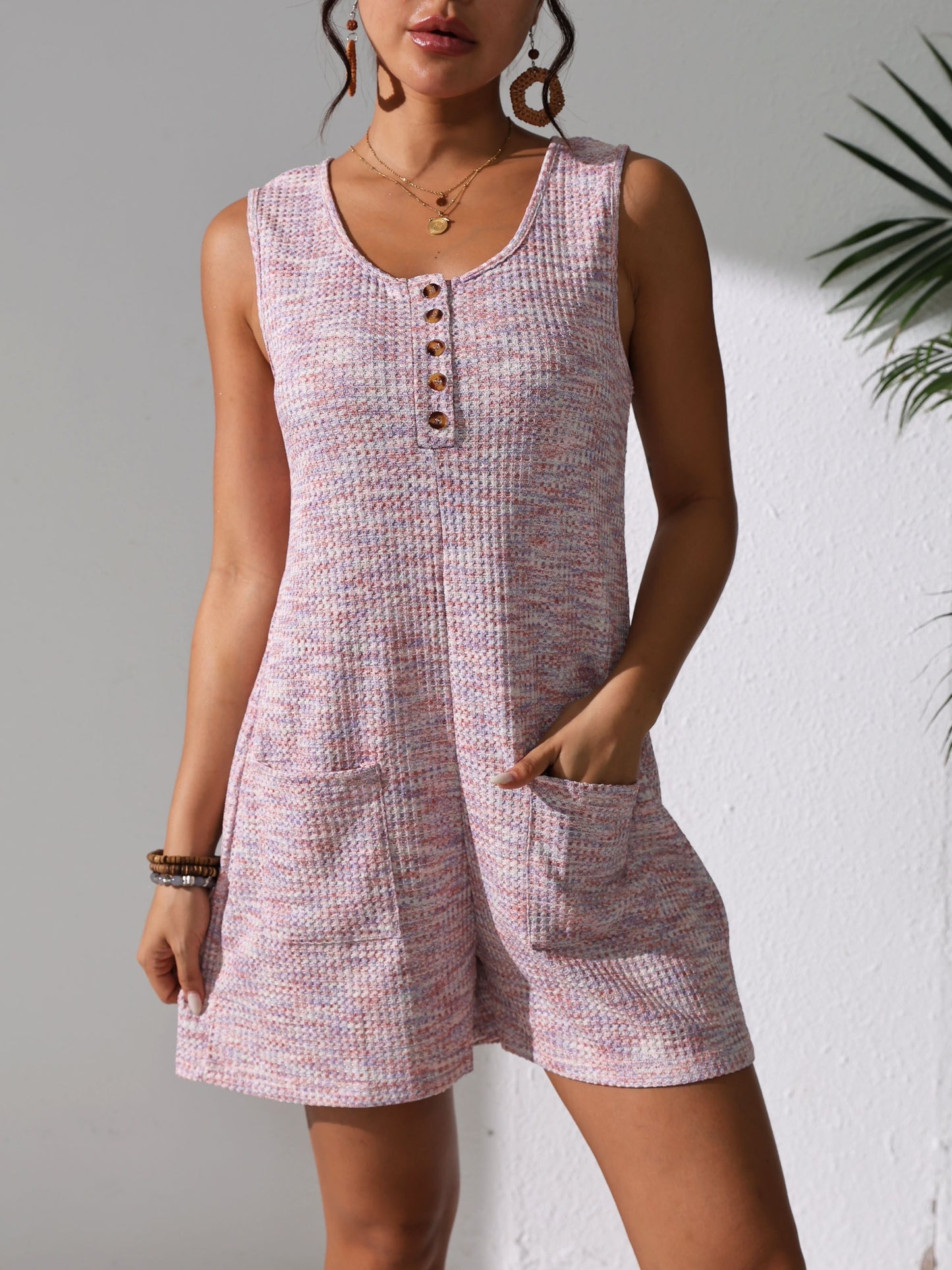 Sleeveless waffle knit romper with pockets for plus-size women in pastel pink. Comfortable and stretchy, perfect for spring/summer.