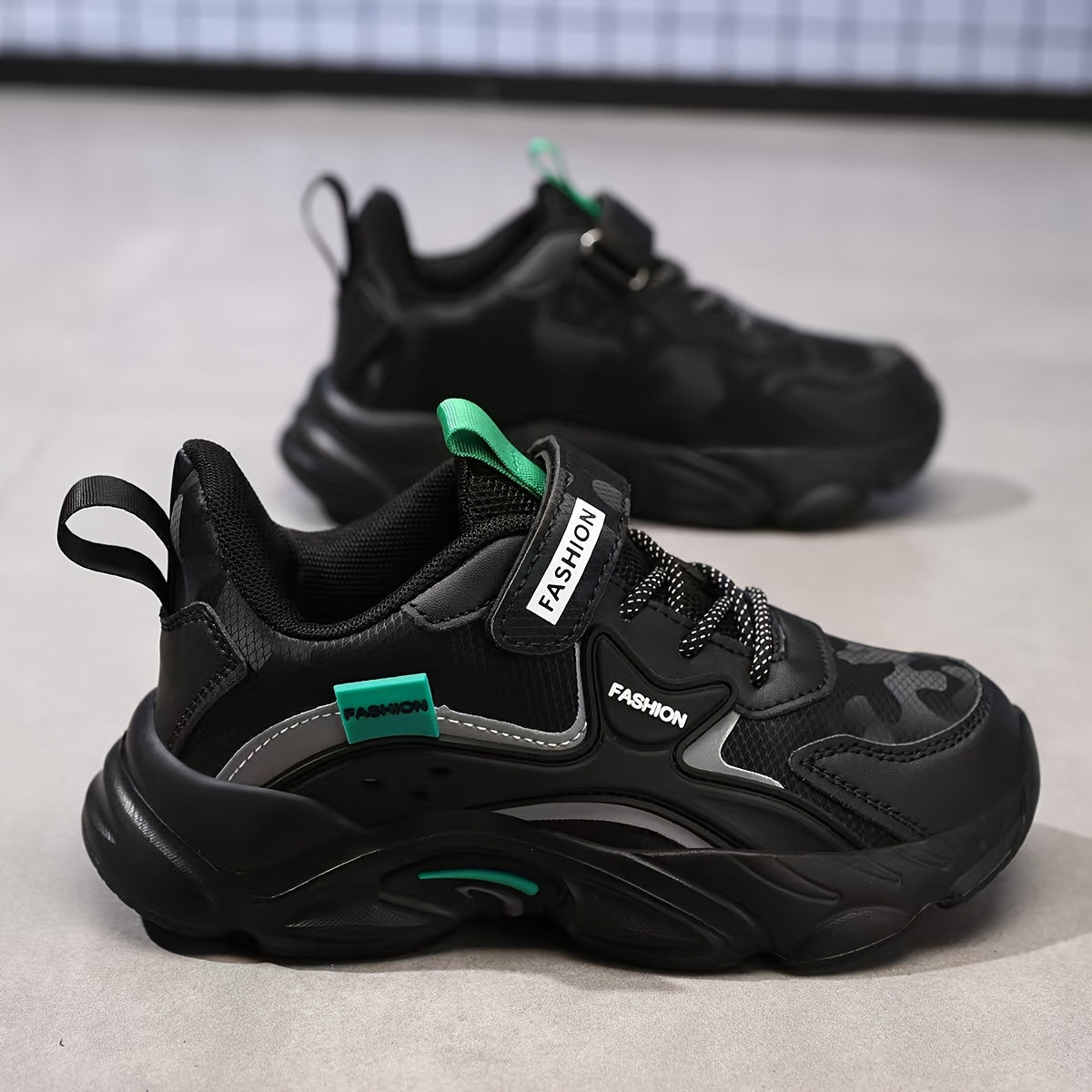 Fashionable boys' athletic sneakers with waterproof, breathable mesh upper and hook-and-loop closure in black and teal design. Ideal for running, sports, and casual wear. Features a stylish