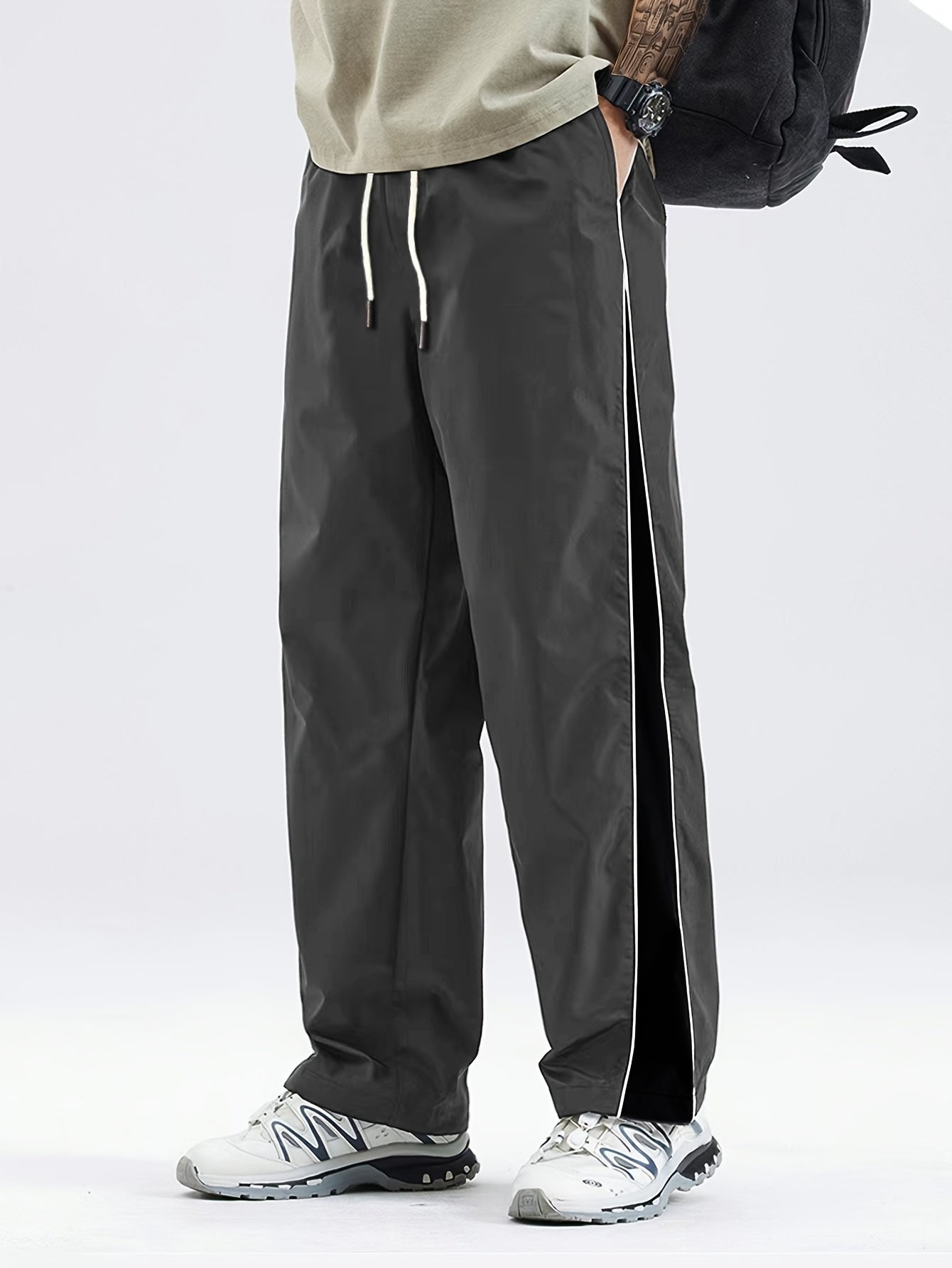 Men's black lightweight joggers with drawstring waist, perfect for spring and fall. Made of polyester fabric with a loose fit and glossy finish.