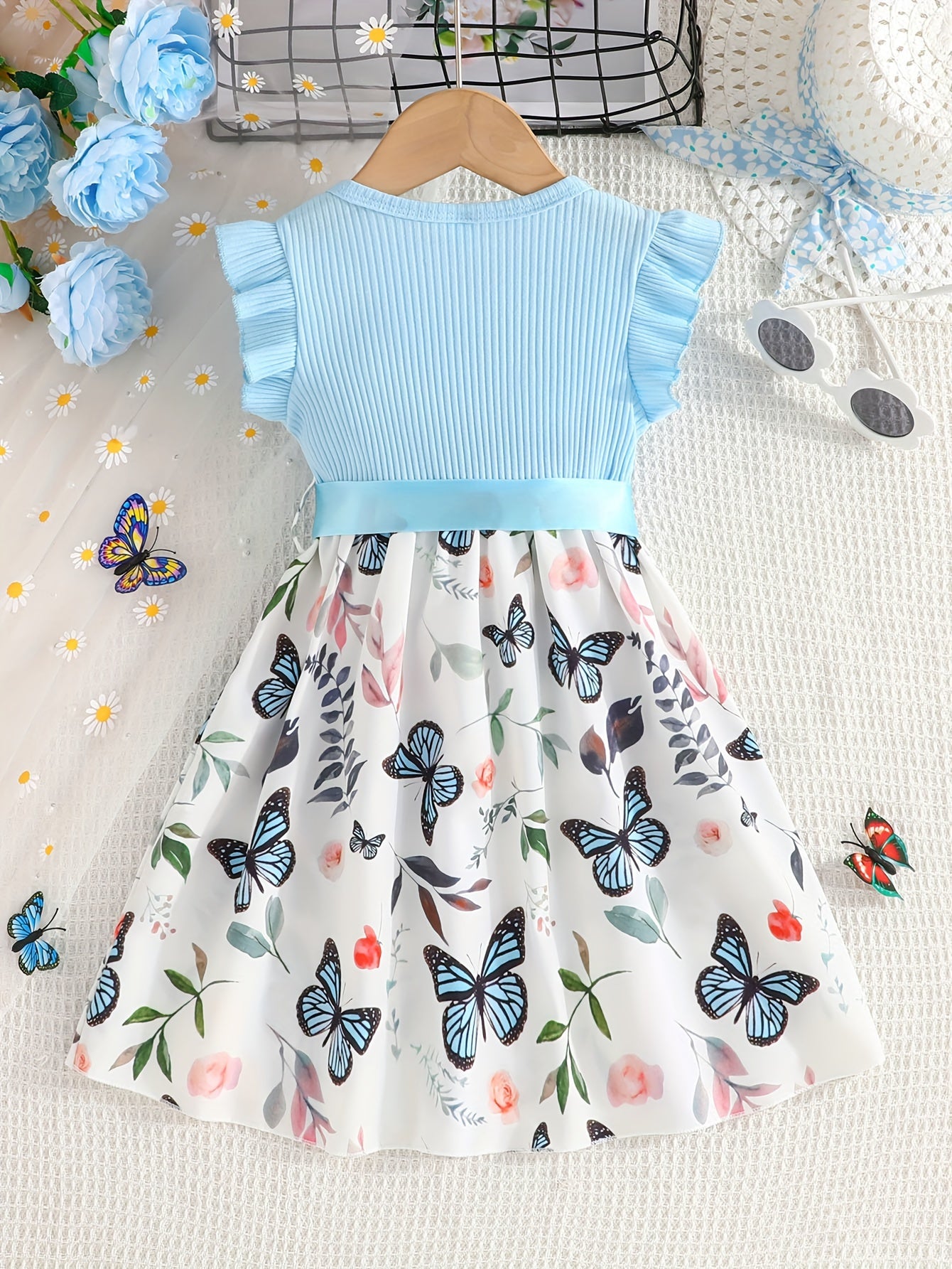 Girls' light blue ribbed cotton dress with butterfly & floral print, flutter sleeves & belt detail. Casual summer wear, machine washable. Dresses for girls.