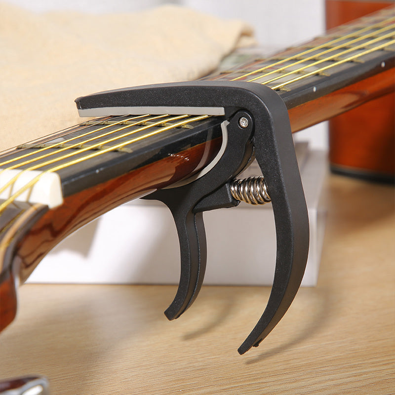 Nylon guitar capo for easy tone adjustment on acoustic, classic, electric guitars, and ukuleles.