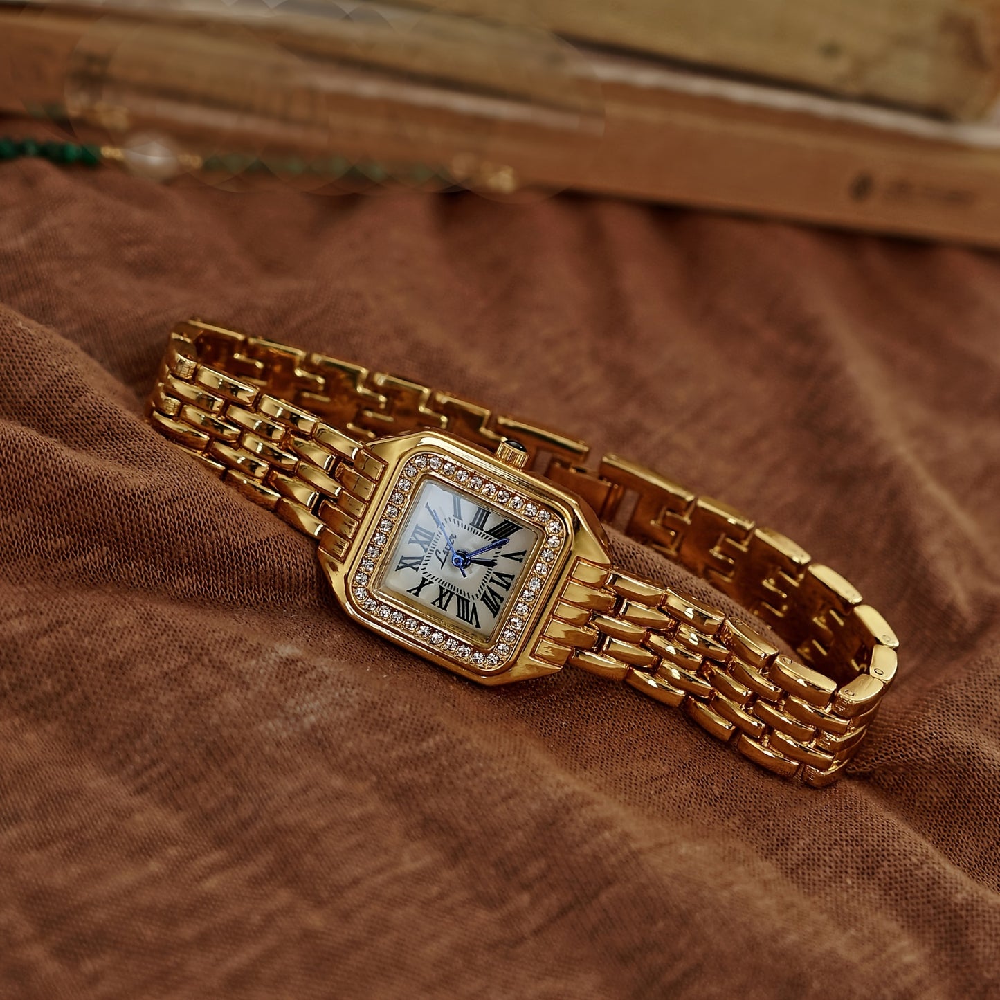 Gold-toned square watch with water drops and Roman numerals, suitable for any occasion.