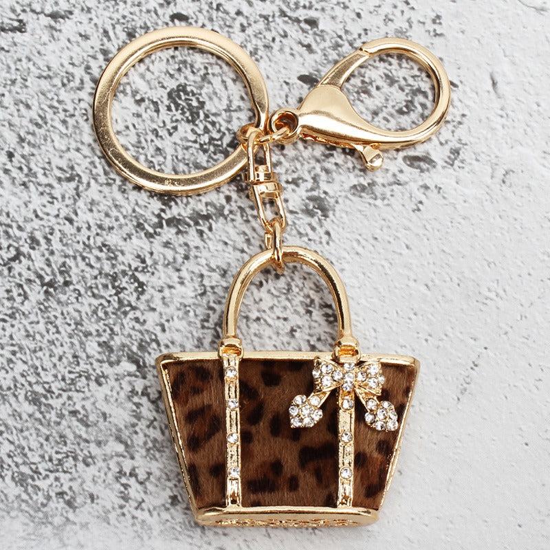 Golden leopard pattern bag shaped keychain pendant, perfect for adding charm to your car, wallet, handbag, or phone. This versatile accessory is also ideal for decorating during the Christmas season, making it a great gift for women.