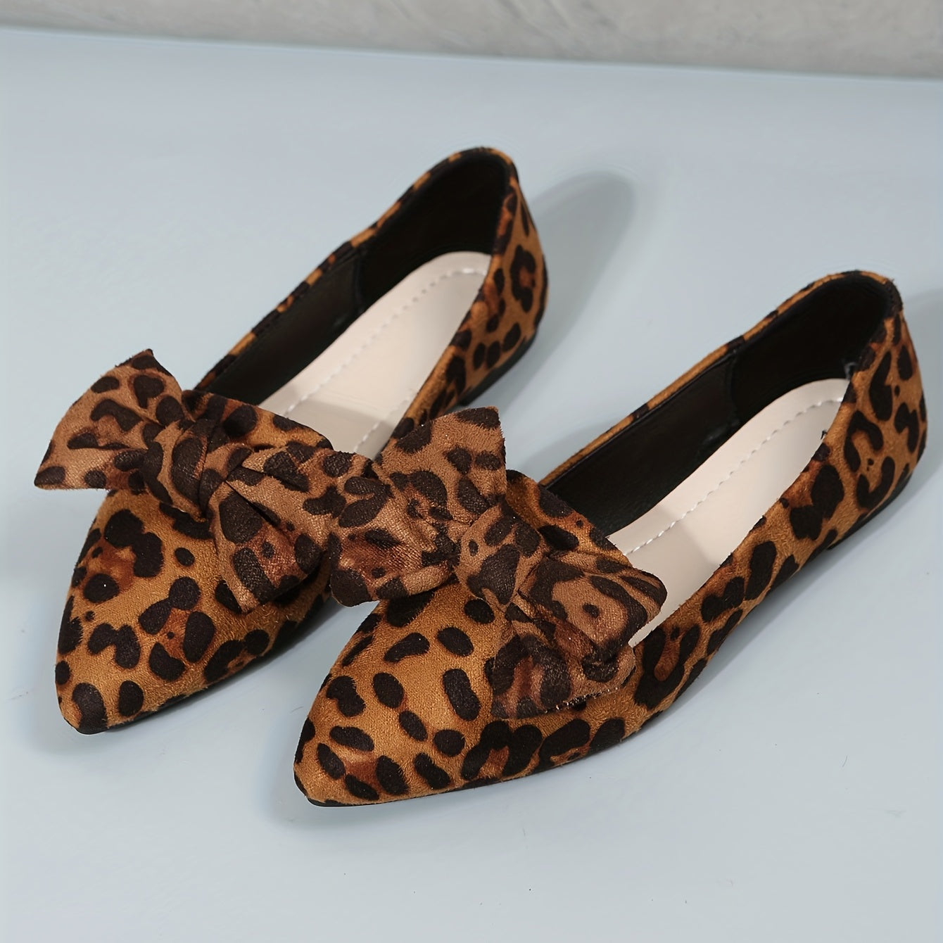 Leopard print flat shoes with bowknot decor and point toe, lightweight slip on style.