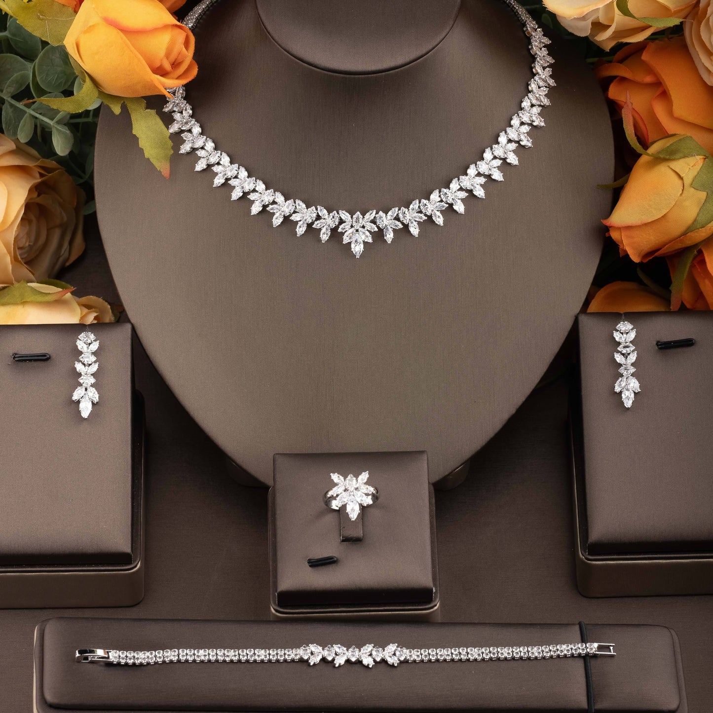 Exquisite set of jewelry adorned with cubic zirconia leaf detailing, including a necklace, earrings, ring, and bracelet, designed for women to enhance their ensemble for weddings and galas.