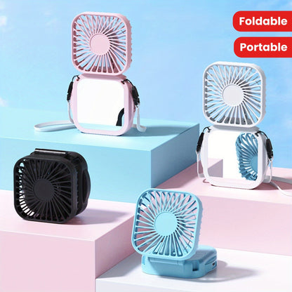 Mini Foldable Desktop Block with Mirror, Multi-functional Handheld Portable Pocket Fan with USB Charging. Can be used as a Hanging Neck Fan or placed on a Desktop. Features Mute Operation and Large Wind Output. Ideal for Creative Desktop Use in the