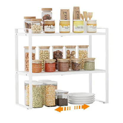 The 2-Tier Expandable Black Metal Cabinet Organizer Riser is a heavy-duty, non-slip storage shelf designed for use in the kitchen pantry, under sink, or on countertops. This stackable organizer is space-saving and features an open storage design, making