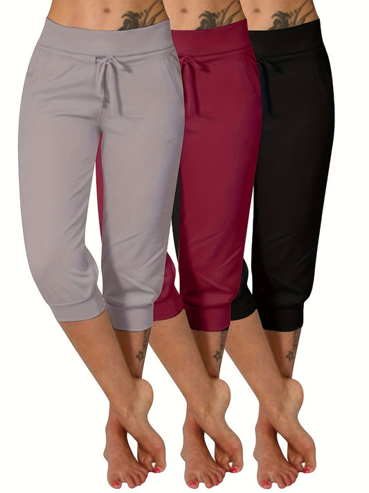 Three maroon plus size women's yoga capris with drawstring, pockets, and stretchy polyester blend fabric.