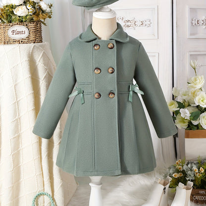 Youthful girls can look stylish in this casual polyester trench coat with lapel collar, double-breasted design, and matching bow detail and hat.